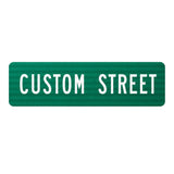 Green flat blade street name sign with reflective texture and white sans-serif text reading CUSTOM STREET.