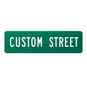 Green flat blade street name sign with reflective texture and white sans-serif text reading CUSTOM STREET.