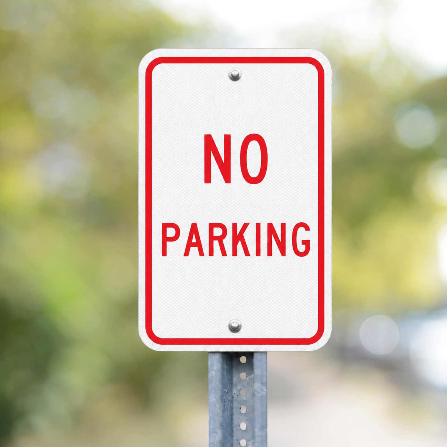 White retroreflective R8-3A "NO PARKING" sign with red text and border, mounted on a metal post.
