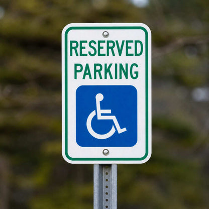 White 12x18 ADA Reserved Parking sign with green text and blue handicap symbol on a metal post.