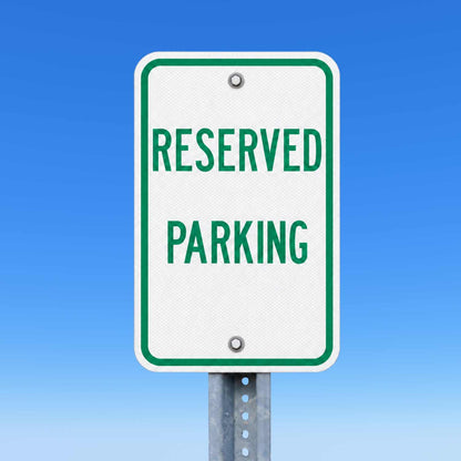 White 12"x18" reserved parking sign with green text and border, mounted on a metal post.