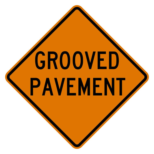 Orange diamond-shaped CW8-15 construction sign with black GROOVED PAVEMENT legend.