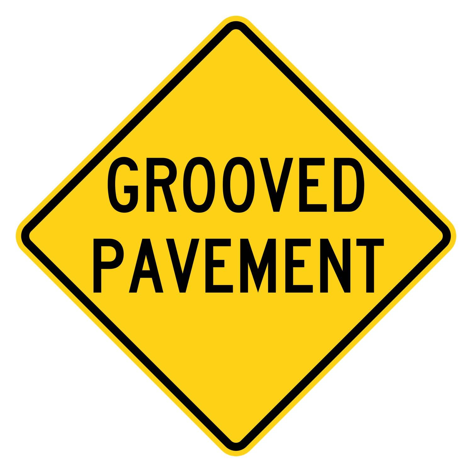 Yellow diamond-shaped W8-15 warning sign with black GROOVED PAVEMENT legend.