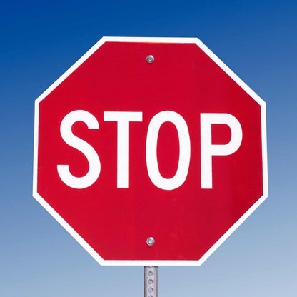 Red octagonal MUTCD STOP sign (R1-1) with white legend, made from reflective aluminum, mounted on a pole.