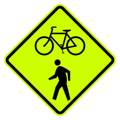 W11-15 diamond-shaped yellow retroreflective sign with black bicycle and pedestrian crossing symbols.