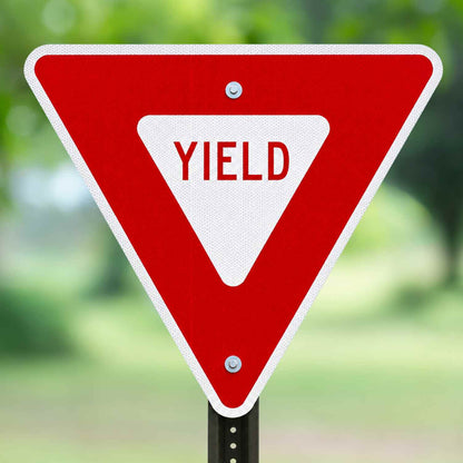 Red and white MUTCD R1-2 Yield Sign, triangular, with "YIELD" in red on a white retroreflective background.